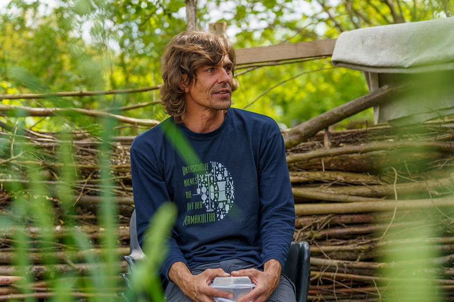 Person sitzt entspannt in einem Sofagarten im Freien, Frühlingsatmosphäre, April 2022